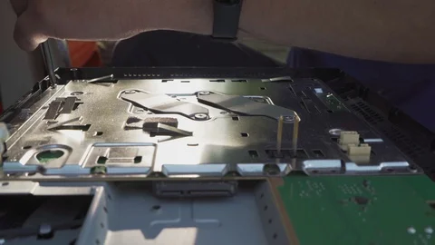 The worker unscrews the screws on the game console board with a screwdriver Stock Footage 108632021