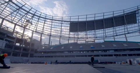 A worker unwinds a roll of ruberoid on a surface of stadium main field  Stock Footage 119626128