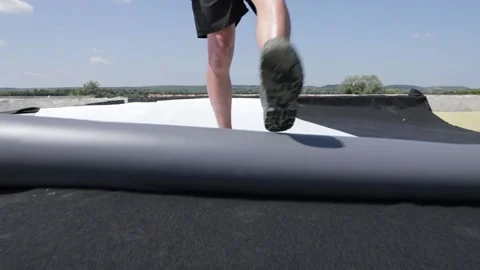Worker unwinds a synthetic pvc membrane roll. Stock Footage 143149391