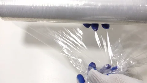 A worker unwinds a wrapping plastic stretch film on a white background. Stock Footage 118777953