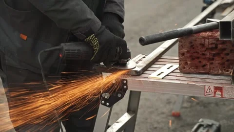 Worker use an Angle Grinder producing. Bright sparks and flashes Stock Footage 263801876