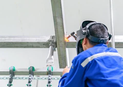 Worker use argon welding stainless truss in chicken meat process line . Stock Photos
