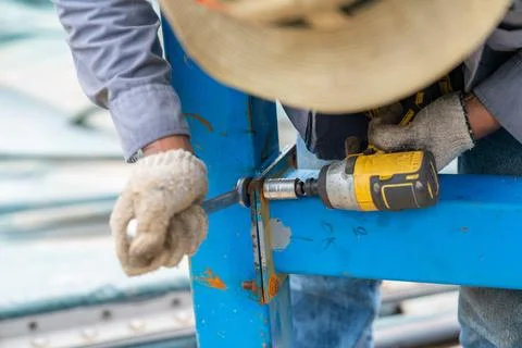Worker use cordless block head screw and wrench remove nut. Stock Photos