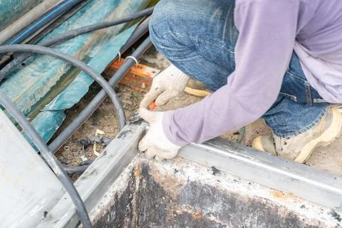 Worker use cutter scrape old rubber gasket edge of pit. Stock Photos