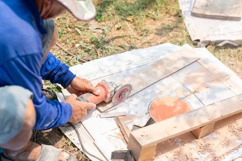 Worker use cutting machine cut a white tile ceramic for assembly Stock Photos