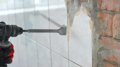 Worker use demolition hammer drill to break up tiles from wall surface Stock Footage 346406200