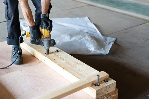 Worker use Drill machine Fasten nut of wooden box packing work in factory Stock Photos