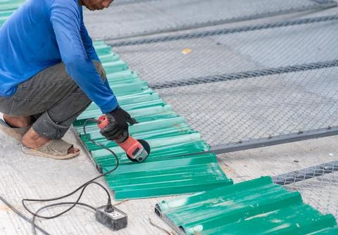 Worker use grinder cutting galvanized metal sheet. Stock Photos