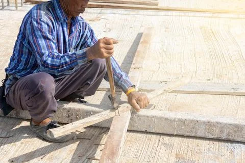 Worker use hammer remove nails on wood stick. Foto stock