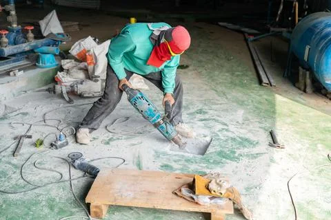Worker use jack hammer drill concrete hold for install foundation. Stock Photos