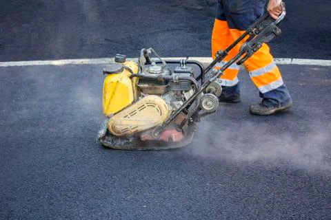 Worker use vibratory plate compactor Stock Photos