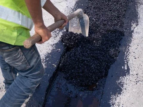 Worker use vibratory plate compactor compacting asphalt at road Foto stock