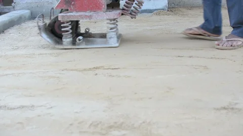 Worker use vibratory plates seals the base sand Stock Footage 98719740