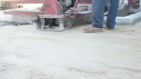 Worker use vibratory plates seals the base sand Stock Footage 98719931