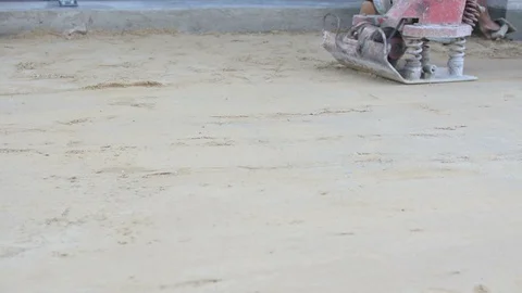 Worker use vibratory plates seals the base sand Stock Footage 98734250