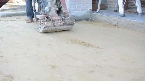 Worker use vibratory plates seals the base sand Stock Footage 98747311