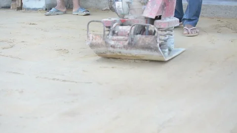 Worker use vibratory plates seals the base sand Stock Footage 98747572