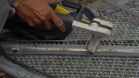 Worker used electric welding wire mesh to make bird cage.001. 4K Stock Footage 114744825