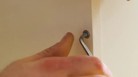 Worker uses Allen key to tighten bolt inserted into plywood Stock-Footage 304396364