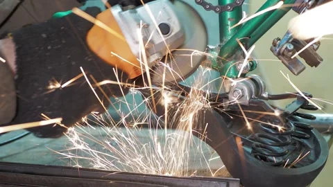 A worker uses a angle grinder on a bicycle to grind the frame. Stock Footage 317499091