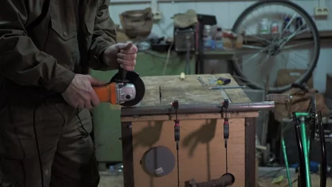 A worker uses a angle grinder to cut a steel pipe . Vídeos de archivo 311759849