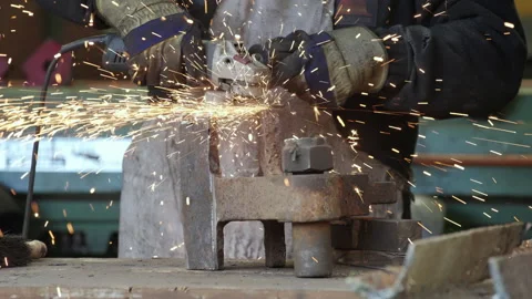 Worker Uses Angle Grinder On Large Piece Of Metal As Sparks Fly - Slow Motion Stock Footage 239456363