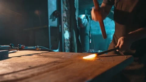 A worker uses a blacksmith hammer in a metallurgical workshop to forge metal. Stock Footage 224945240