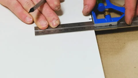 Worker uses conductor marking place for hole on white board Stock Footage 304401754