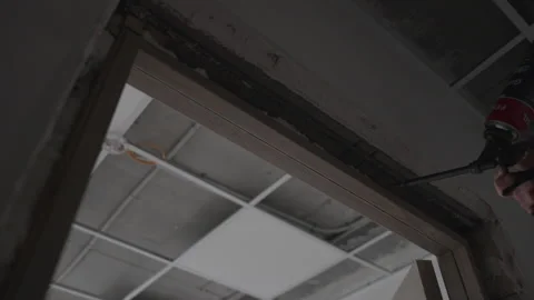 Worker uses construction foam around office door frame edge 動画素材 309770045