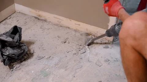 Worker uses a demolition hammer to break apart a concrete. Fragments and dust 库存影片 318993135