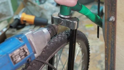 A worker uses a drill to make a hole in the steering fork. Stock Footage 317499281