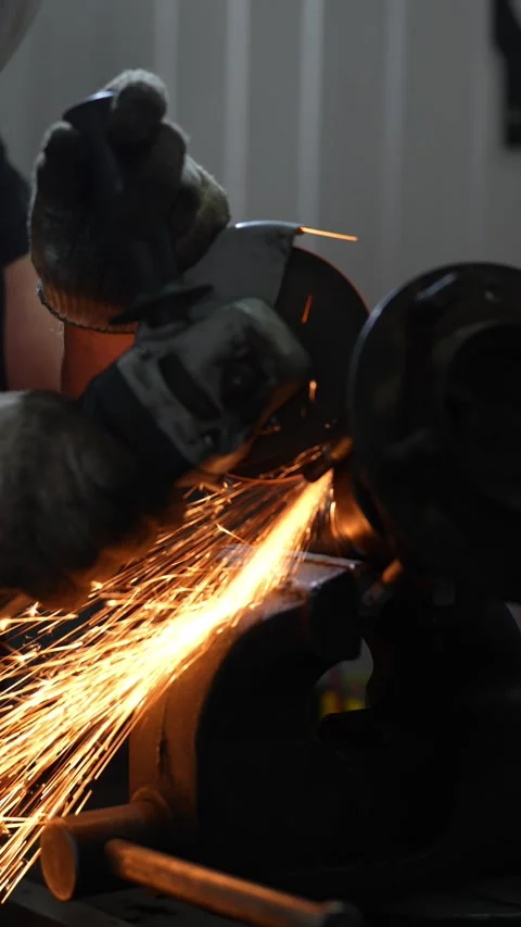 Worker uses electric angle grinder cutting machine on automotive hub Stock Footage 344230611