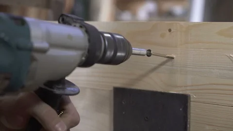 Worker uses electric screwdriver to connect planks on wooden construction. Stock Footage 98483455