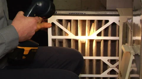 Worker uses a flashlight to inspect a HVAC filter Stock Footage 42964119