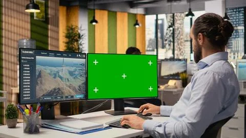 Worker uses green screen mockup PC to optimize advanced VAWT wind farm Stock Photos