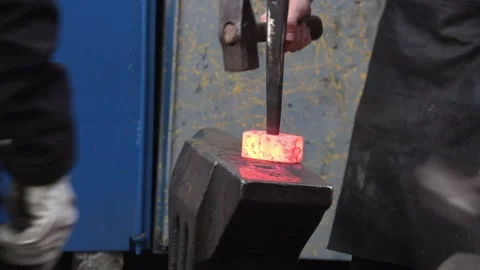 Worker Uses Heavy Hammer to Shape Glowing Metal on Blacksmith Anvil 库存影片 348913337