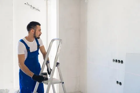 The worker uses a laser level for marking Stock Photos