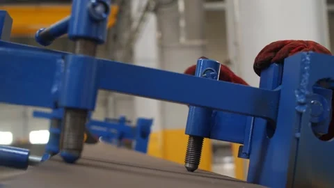 Worker uses manual clamp to secure metal sheet in metallurgy manufacturing. Stock Footage 313815342