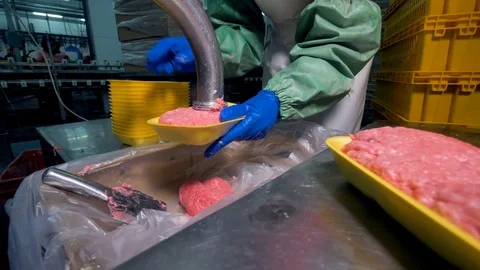 A worker uses many plastic trays to pack ground meat. Stock Footage 79830365