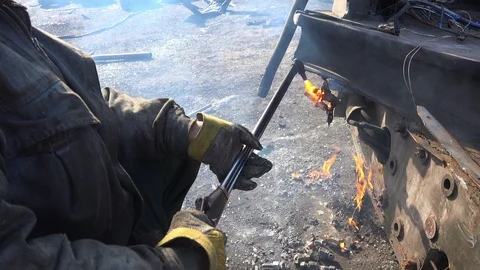 A worker uses a oxygen acetylene cutting torch to cut scrap Stock Footage 103682058