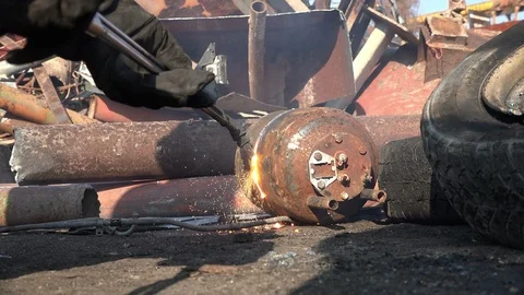 A worker uses a oxygen acetylene cutting torch to cut scrap Stock Footage 104920134