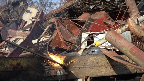 A worker uses a oxygen acetylene cutting torch to cut scrap Stock Footage 104921944
