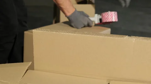 Worker uses parcel tape gun for packaging cardboard box Video stock 266151158