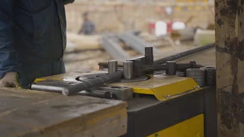 Worker uses rebar bending machine to shape steel rod Vídeos de archivo 303149574