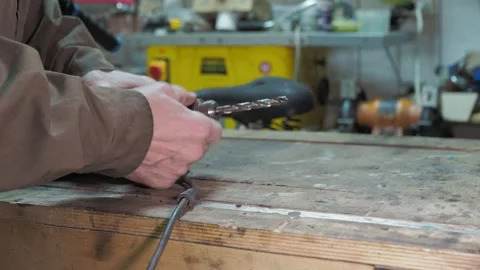 The worker uses a special key to replace the drill bit in the drill head. Stock-Footage 317499330