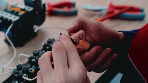 The worker uses tools to assemble the electrical circuit on the table Stock Footage 141263514