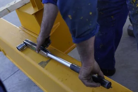 A worker uses a torque wrench. 스톡 사진