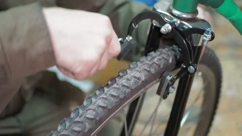A worker uses a wrench to install rim brakes on a bicycle. 스톡 동영상 317499323