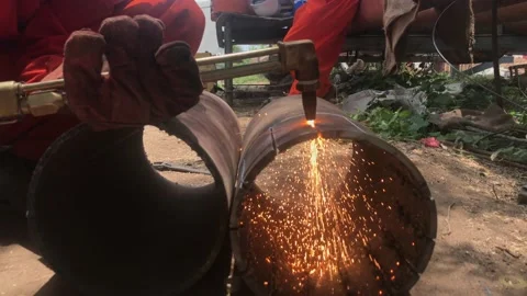 Worker using acetylene torch to cut pipe. Stock Footage 157283400