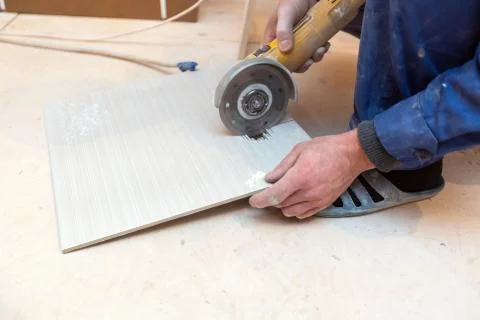 Worker is using angle grinder in apartment that is under construction Stock Photos